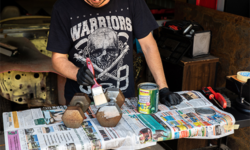 Man using wire brush to clean gym weights